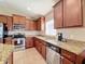 Modern kitchen with granite counters and wood cabinets at 10718 Standing Stone Dr, Wimauma, FL 33598