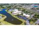 An aerial view of the clubhouse, lake, surrounding neighborhood, and convenient parking at 2222 Greenhaven Dr, Sun City Center, FL 33573