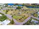 Aerial view of a park with a gazebo, walking paths, and landscaping near a pond and community buildings at 2222 Greenhaven Dr, Sun City Center, FL 33573