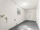 Unfinished basement with painted concrete walls and floor, featuring a window and utility hookups at 2222 Greenhaven Dr, Sun City Center, FL 33573