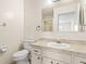 Well-lit bathroom with a vanity, toilet, and shower with glass door at 2222 Greenhaven Dr, Sun City Center, FL 33573