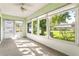 Bright sunroom featuring large windows offering abundant natural light and views of the landscaped yard at 2222 Greenhaven Dr, Sun City Center, FL 33573