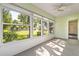 Cozy sunroom with neutral carpet and a ceiling fan, offering views of the outdoor landscape at 2222 Greenhaven Dr, Sun City Center, FL 33573