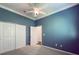 Spacious bedroom with ceiling fan, carpet, and double doors at 4977 Sapphire Sound Dr, Wimauma, FL 33598