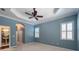 Bright bedroom with ceiling fan and white shutters at 4977 Sapphire Sound Dr, Wimauma, FL 33598