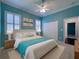 Bedroom featuring a queen-size bed, neutral decor, and a view into an ensuite bathroom, creating a relaxing retreat at 4977 Sapphire Sound Dr, Wimauma, FL 33598