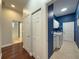 Clean hallway with hardwood floors, leading to laundry and bathroom at 4977 Sapphire Sound Dr, Wimauma, FL 33598
