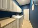 Convenient laundry room with washer, dryer, cabinets, and utility sink at 4977 Sapphire Sound Dr, Wimauma, FL 33598