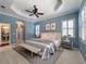 A main bedroom features a tray ceiling, ceiling fan, neutral decor, and an ensuite bathroom at 4977 Sapphire Sound Dr, Wimauma, FL 33598