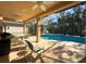 Relaxing covered patio overlooking the pool and lush landscaping at 4977 Sapphire Sound Dr, Wimauma, FL 33598