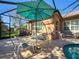 Relaxing covered patio with seating area, umbrella, and adjacent pool at 4977 Sapphire Sound Dr, Wimauma, FL 33598