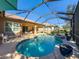 Inviting kidney-shaped pool with a screened enclosure and patio seating at 4977 Sapphire Sound Dr, Wimauma, FL 33598