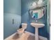 Modern powder room with pedestal sink and blue walls at 4977 Sapphire Sound Dr, Wimauma, FL 33598