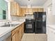 Kitchen features wood cabinets and black appliances at 2222 Greenhaven Dr, Sun City Center, FL 33573