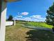 Landscaped backyard with a large tree and open field views at 11883 Brighton Knoll Loop, Riverview, FL 33579