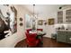 A breakfast nook features a round table, red chairs and a large piece of art at 2539 Silverback Ct, Palm Harbor, FL 34684