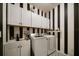 Laundry room with white cabinets, washer, dryer and black and white striped walls at 2539 Silverback Ct, Palm Harbor, FL 34684