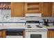 Bright kitchen with wood cabinets, white appliances, and decorative backsplash at 36750 Kimela Ave, Zephyrhills, FL 33542