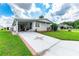 Mobile home with covered patio, landscaped yard, and driveway at 36750 Kimela Ave, Zephyrhills, FL 33542