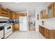 Open kitchen features wood cabinets, white appliances, and tile flooring at 36750 Kimela Ave, Zephyrhills, FL 33542