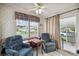 Cozy living area with two armchairs and a game table near sliding door at 36750 Kimela Ave, Zephyrhills, FL 33542