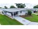 Mobile home with covered patio, landscaping, and driveway at 36750 Kimela Ave, Zephyrhills, FL 33542