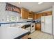 Galley kitchen, white appliances and wood cabinets at 36750 Kimela Ave, Zephyrhills, FL 33542