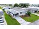 Mobile home community with paved road and lush landscaping at 36750 Kimela Ave, Zephyrhills, FL 33542