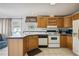 Kitchen with white appliances and wood cabinets at 36750 Kimela Ave, Zephyrhills, FL 33542