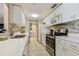 Modern kitchen with white cabinets, quartz countertops, and stainless steel appliances at 36750 Us Highway 19 N # 04308, Palm Harbor, FL 34684