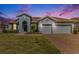 Stunning home exterior at dusk with a 2-car garage and well-manicured lawn at 19879 Tattnall Way, Brooksville, FL 34601