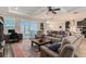 Open-concept living room with comfortable seating, area rug, and natural light from large windows at 19879 Tattnall Way, Brooksville, FL 34601