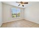 Bright bedroom with ceiling fan, tile floors, and a large window overlooking a green landscape at 5608 Pinnacle Heights Cir # 305, Tampa, FL 33624