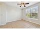 Bedroom offers a ceiling fan and tile flooring plus a window with neighborhood views at 5608 Pinnacle Heights Cir # 305, Tampa, FL 33624
