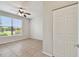 Bedroom showcasing neutral tile floors, view from the window and a double door closet at 5608 Pinnacle Heights Cir # 305, Tampa, FL 33624