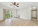 Spacious living room with tile flooring, ceiling fan, and sliding glass doors to a balcony at 5608 Pinnacle Heights Cir # 305, Tampa, FL 33624