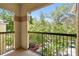 An outdoor patio view with lush green trees beyond the railing at 5608 Pinnacle Heights Cir # 305, Tampa, FL 33624