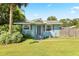 Light blue single story house with gray door, landscaping, and a well-maintained lawn at 6030 62Nd N St, St Petersburg, FL 33709