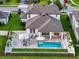 Aerial view of a backyard featuring a pool, patio, outdoor seating, and well-manicured landscaping at 11828 Ranchers Gap Dr, Odessa, FL 33556