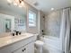 Bathroom featuring a modern vanity with granite countertop, framed mirror, and tiled shower at 11828 Ranchers Gap Dr, Odessa, FL 33556