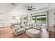 Spacious living room with a large sofa, wood floors, access to the pool and outdoor space at 11828 Ranchers Gap Dr, Odessa, FL 33556