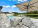 Backyard patio with comfortable outdoor seating, a pool, and a scenic view of a tranquil lake at 11828 Ranchers Gap Dr, Odessa, FL 33556