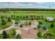 Overhead view of a colorful community playground with various play structures, surrounded by green space and trees at 11828 Ranchers Gap Dr, Odessa, FL 33556