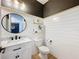 Chic powder room with shiplap walls, granite countertop, and designer mirror at 11828 Ranchers Gap Dr, Odessa, FL 33556