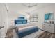 Comfortable staged bedroom with a blue bed frame, soft lighting, and a calming ambiance at 14130 Rosemary Ln # 2208, Largo, FL 33774