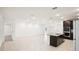 Spacious kitchen with a central island, modern appliances, dark cabinets, and tile flooring throughout at 4013 Chadwick Ave, Spring Hill, FL 34609