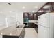 Modern kitchen featuring granite countertops, stainless steel appliances, and dark wood cabinetry at 4013 Chadwick Ave, Spring Hill, FL 34609