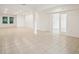 Bright living room showcasing neutral tile flooring, recessed lighting, and a seamless transition to the outdoor space at 4013 Chadwick Ave, Spring Hill, FL 34609