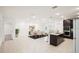 Bright open-concept space with dining area, kitchen island, and dark cabinets and stainless appliances at 4013 Chadwick Ave, Spring Hill, FL 34609