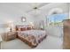 Bedroom with beautiful light, featuring a queen bed, lamps, and stylish decor at 651 Garland Cir, Indian Rocks Beach, FL 33785